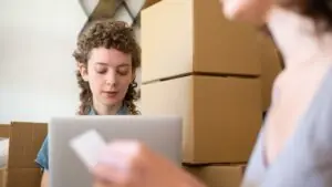 Nhân sự xử lý đơn hàng bằng laptop để tạo yêu cầu báo giá logistics