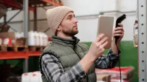 Nhân sự kho dùng máy quét và máy tính bảng để tra cứu trạng thái hàng