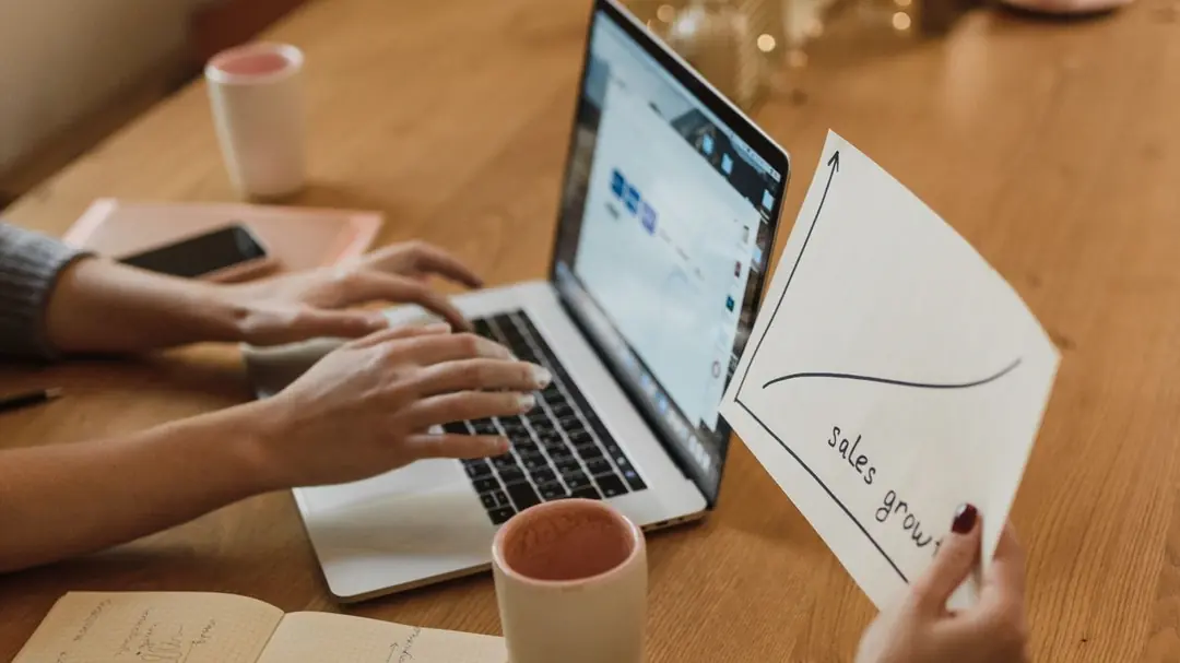 nhóm sales phân tích biểu đồ tăng trưởng và pipeline báo giá trên laptop